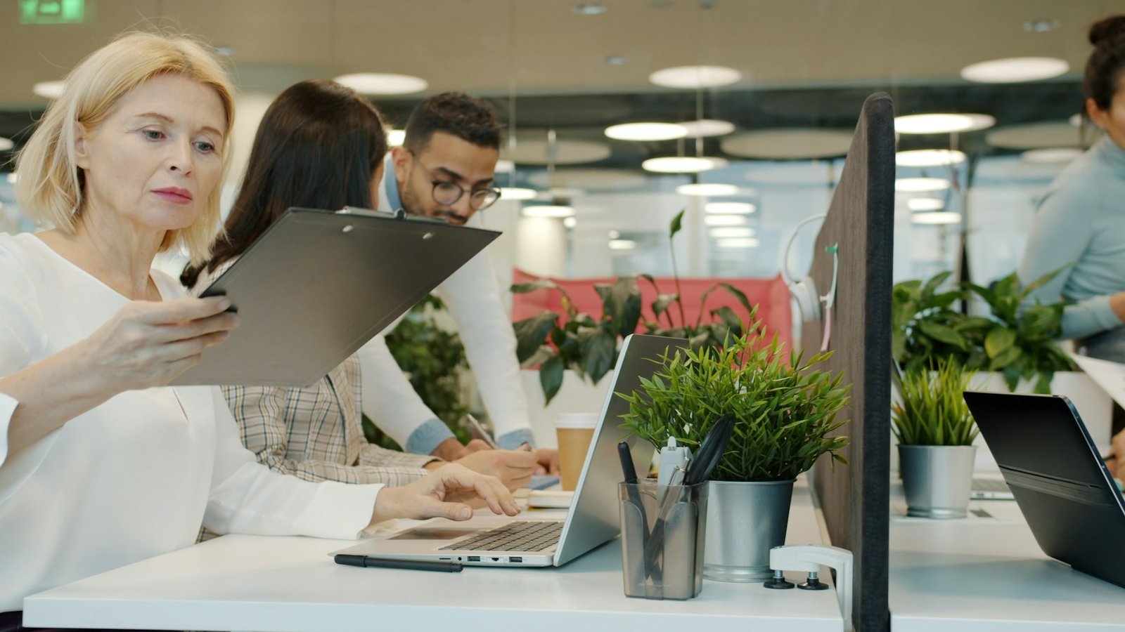 Une équipe échange autour d’un écran dans un bureau contemporain